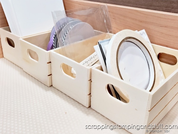 Click to see 12 ways to use a dollar tree crate for craft room organization! Organize your adhesives, embellishments, ink pads and more using a $1 wood crate!